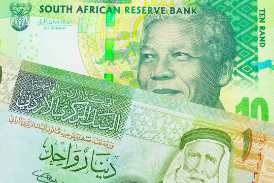 A macro image of a shiny, green 10 rand bill from South Africa paired up with a green and yellow one dinar note from Jordan.  Shot close up in macro.