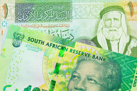 A macro image of a shiny, green 10 rand bill from South Africa paired up with a green and yellow one dinar note from Jordan.  Shot close up in macro.