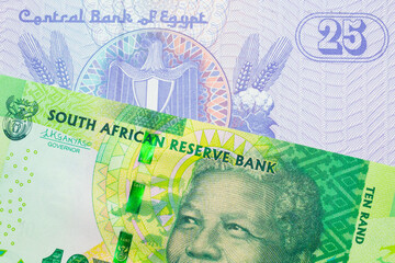 A macro image of a shiny, green 10 rand bill from South Africa paired up with a blue twenty five piastre bank note from Egypt.  Shot close up in macro.