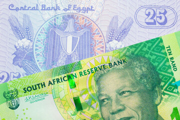 A macro image of a shiny, green 10 rand bill from South Africa paired up with a blue twenty five piastre bank note from Egypt.  Shot close up in macro.