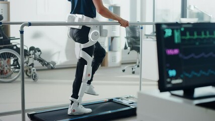 Modern Hospital Physical Therapy: Patient with Injury Walks on Treadmill Wearing Advanced Robotic Exoskeleton Legs. Physiotherapy Rehabilitation Technology to Make Disabled Person Walk. Focus on Legs