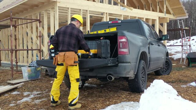 Caucasian Construction Contractor Preparing Himself and His Toolbox in Front of His Modern Pickup Truck. Construction Zone Job Theme.