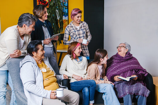 Latin Family Three Generation Of Mexican Women Sitting On Sofa In Mexico City