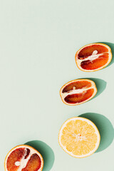Bright slices citrus fruits, grapefruit, orange on pastel color fon. Fruit food and summer concept. Top view with sunlight.