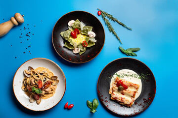 Directly above view of assortment of italian meals on bright background: pasta, ravioli and lasagna