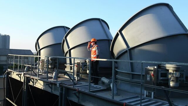 Engineer under checking the industry cooling tower air conditioner is water cooling tower air chiller HVAC of large industrial building to control air system.