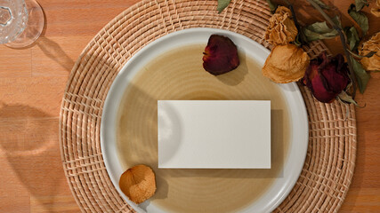 Dining set with mock up name card on mock up ceramic plate and flower