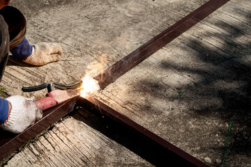 Obraz premium A man welding stell on the concrete floor