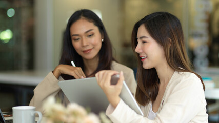 Businesswomen working together and talking to each other in meeting room