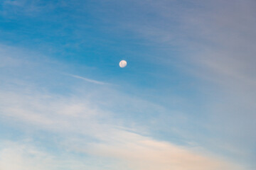 White clouds and the moon in a blue sky