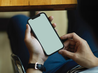 Male hands using smartphone include clipping path while sitting at workspace