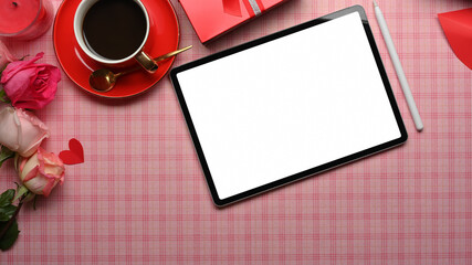 Feminine workspace with digital tablet, coffee cup, flower and gift box decorated on the table