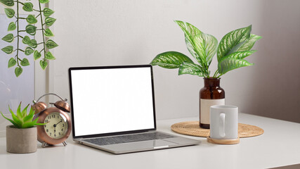 Biophilia workspace with laptop, cup, decorations and plant vase in home office room