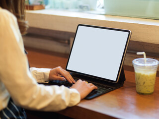 Female hand using digital tablet include clipping path with keyboard in cafe