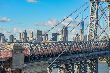 Close up bridge shot in Manhattan, NYC, New York City on a beautiful, blue sky day in winter time with sun shining on city landscape in background. 