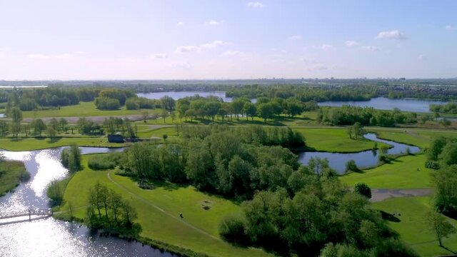Aerial shot of the beautiful natural landscape with lakes and green trees; the vast, quiet, beautiful waters with ditches, canals and reeds in Landsmeer, North Holland, the Netherlands.