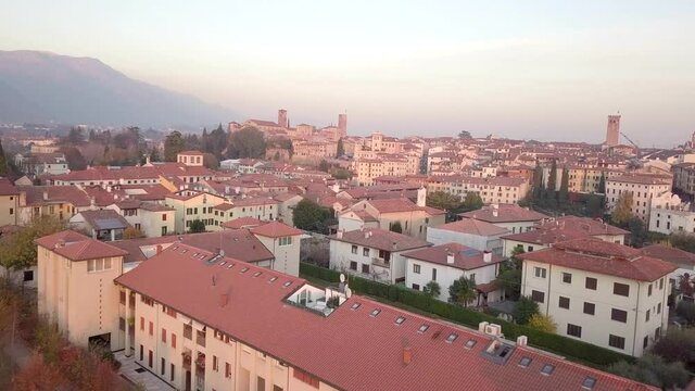 Aerial flyover old historic city during sunset and mountains in background. Bassano del Grappa,Italy.