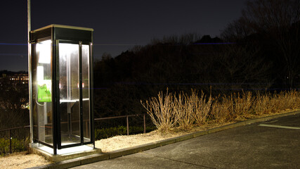 Tokyo,Japan-February 3, 2021: Isolated telephone booth in the dark of night
 - Powered by Adobe