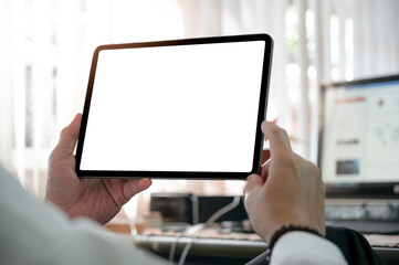 Cropped shot of man hands holding blank screen tablet while sitting at office desk.