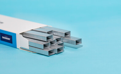 Metal staple concept isolated on blue background.
