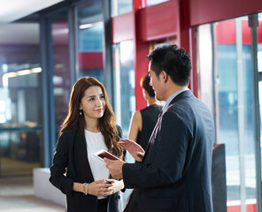 asian corporate executives discussing business in company lobby