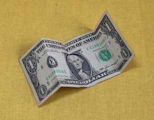 A one-dollar paper bill folded four times.
