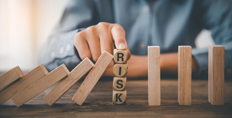 close-up hand The hand of a businessman who is stopping or preventing a falling block.Risk...