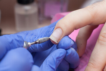 Male manicure in the salon. The process of removing the gel polish, cleaning the nail plate, forming the shape..