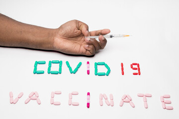 Syringe in African American hand with pills emphasizing the Coronavirus Vaccination during Covid 19