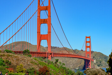 A stunning, perfect blue sky day in San Francisco, California during summer time. Iconic, red Golden Gate Bridge.  - Powered by Adobe