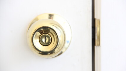 Detail of a golden handle on a white wooden door