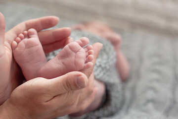 Close-up of newborn legs in woman hands