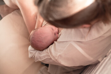 Mother holding newborn baby and breastfeedidiing little infant kid in hands
