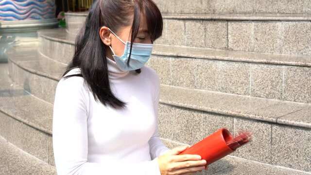 Asian woman shaking fortune Sticks or Seam-si for fortune