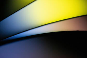 Background macro image pattern made of folded curved sheets of paper with multi color light illuminate  