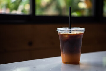 Iced coffee with orange juice On the wooden table in the cafe,Vintage style.