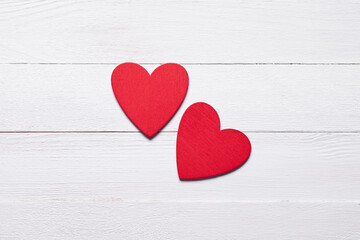 Two red hearts on white wooden background 