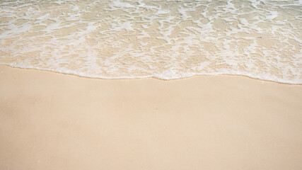 Fototapeta na wymiar Clear sea waves and white sandy beach in summer.