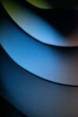 Background macro image pattern made of folded curved sheets of paper with multi color light illuminate  