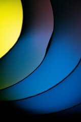 Background macro image pattern made of folded curved sheets of paper with multi color light illuminate  