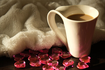 Cup of coffee or tea, crystal hearts and fur plaid on  bed, the concept of home comfort, romantic congratulation. Romantic morning surprise, love for coffee and St. Valentine's day