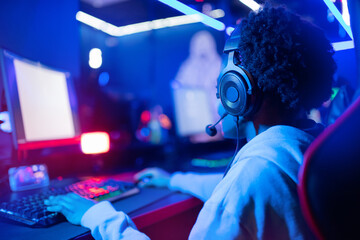 Professional Streamer African young woman cyber gamer in neon color blur background © Parilov