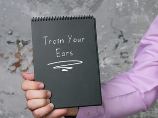Motivational concept meaning Train Your Ears with sign on the piece of paper.