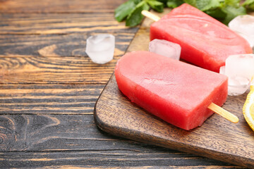 Board with watermelon ice cream on wooden background