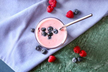 Glass of tasty smoothie with blueberry and raspberry on color background