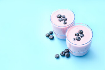 Obraz na płótnie Canvas Glasses of tasty blueberry smoothie on color background