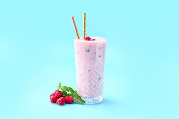 Glass of tasty raspberry smoothie on color background
