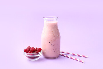 Bottle of tasty raspberry smoothie on color background