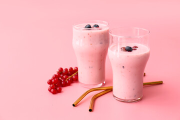 Glasses of delicious smoothie with blueberry and cranberry on color background