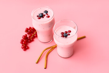 Glasses of delicious smoothie with blueberry and cranberry on color background